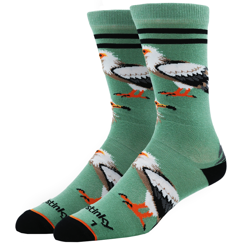 A pair of Stinks brand crew socks in sage green, featuring a graphic print of bald eagles and coqui frogs, with black stripes near the top and black heels and toes.